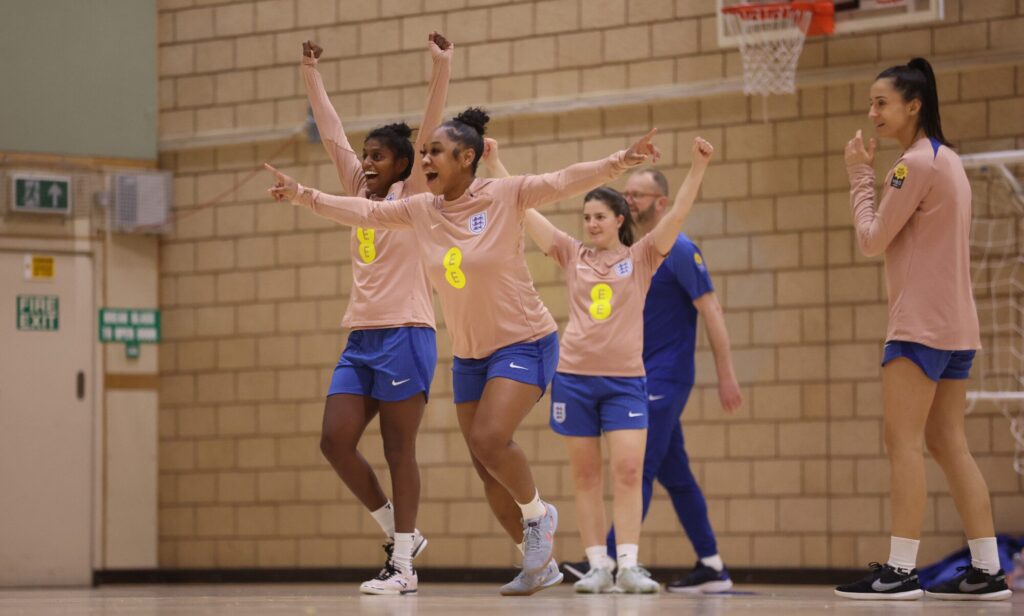 England women's football team celebrating during training session.