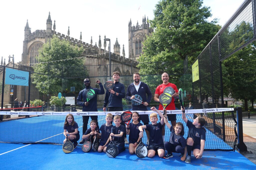 Group of children and adults playing padel tennis in Manchester.
