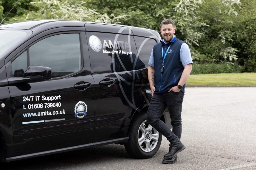 Amita IT support van parked with technician standing beside it.
