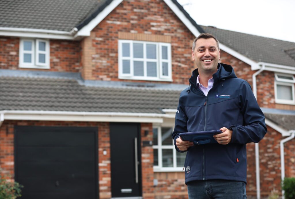 A residential surveyor captured while conducting a survey outside a house.