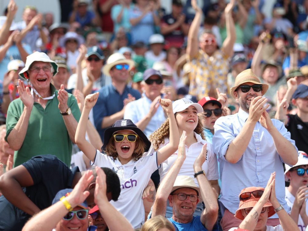 Enthusiastic cricket fans celebrating at a match.