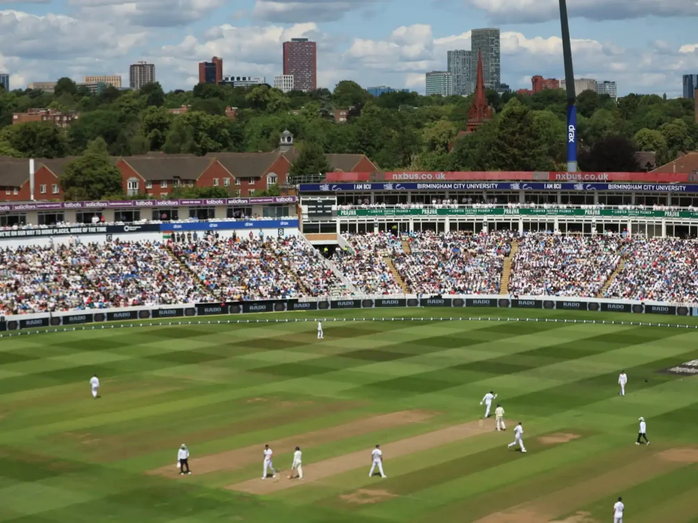 A sunny day at Edgbaston Stadium, featuring players on the field and a packed audience.