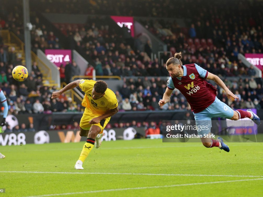 Dramatic moment in a football match between Brentford and Burnley, showcasing players in action.