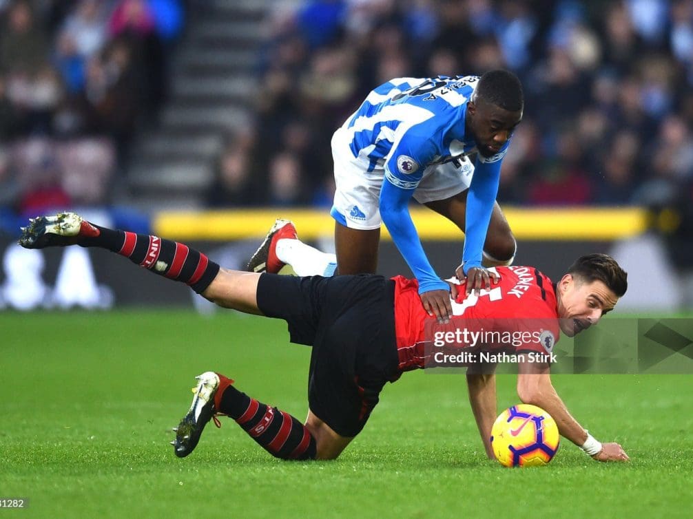 Intense football tackle during a Premier League match.
