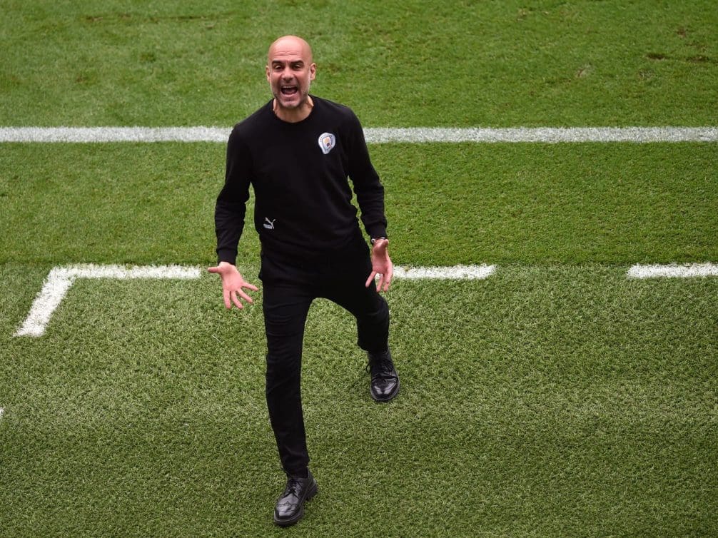 Pep Guardiola passionately coaching during a football match.