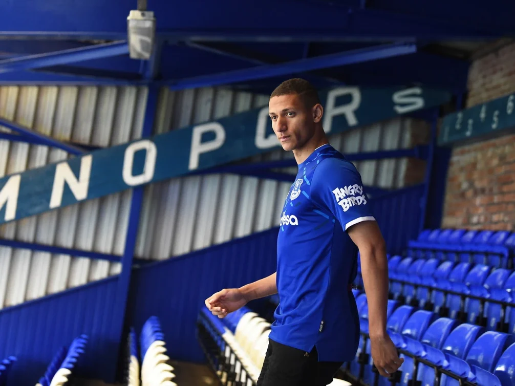 Richarlison walking through Everton stadium seating area.