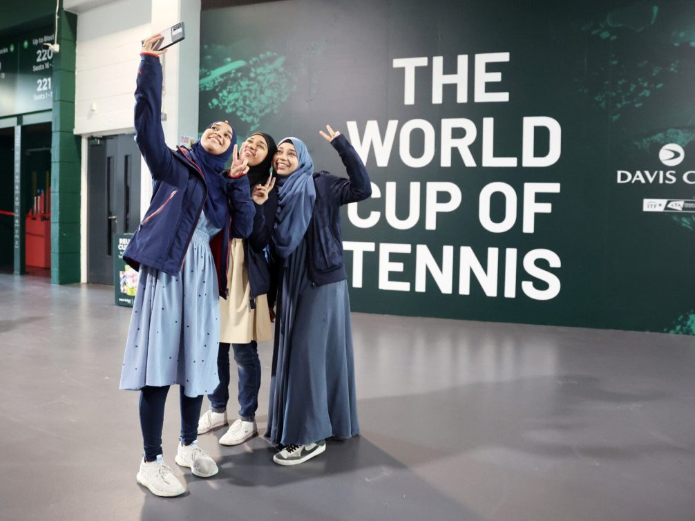 Friends capturing a selfie at the Davis Cup tennis tournament.